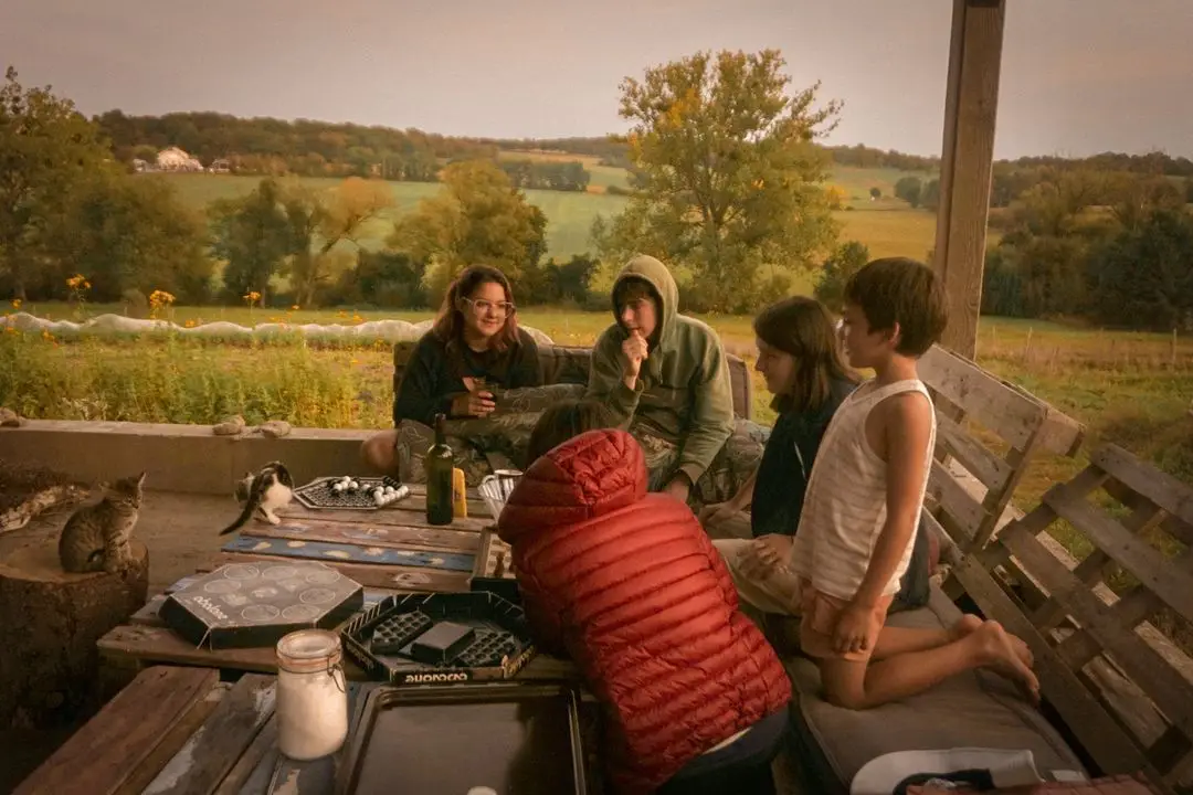 A family relaxes together on a porch overlooking the countryside.