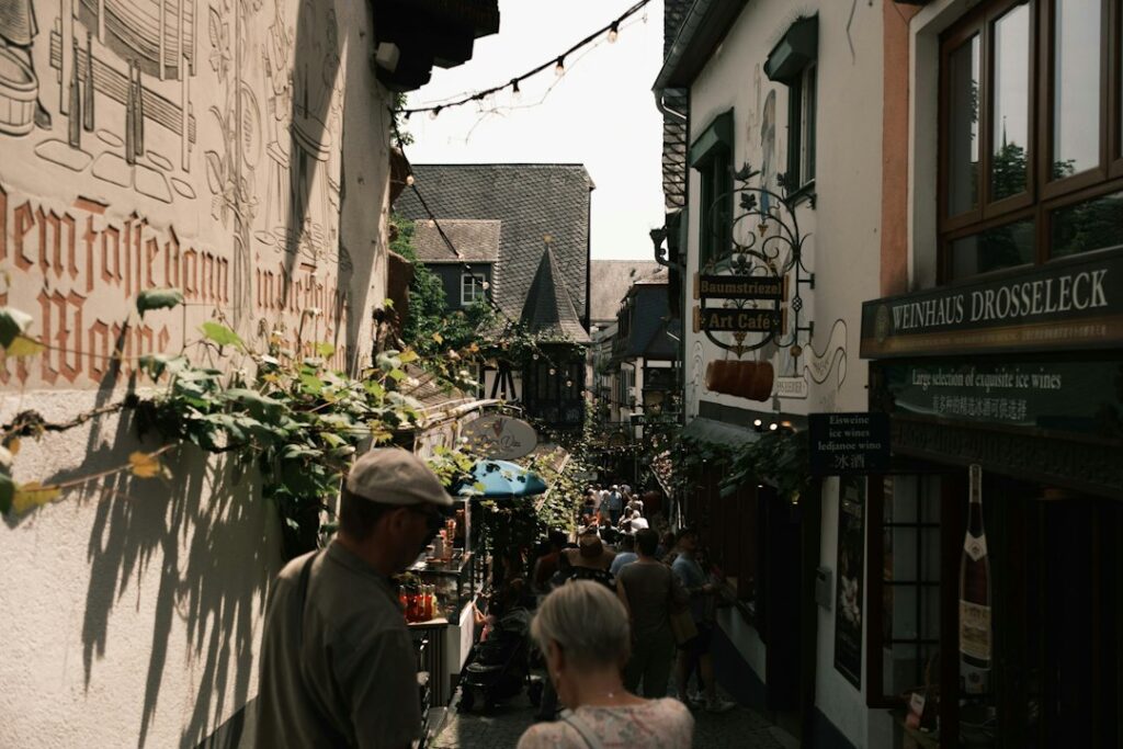 Two people walking and talking down a narrow, historic old-town street