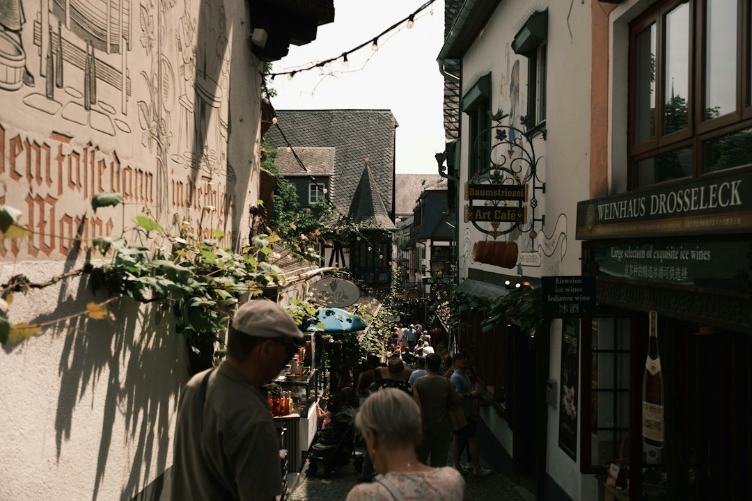 Two people walking and talking down a narrow, historic old-town street